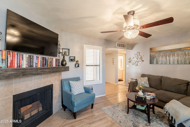 8787 E Mountain View Rd Unit 1110, Scottsdale, AZ 85258 - living room with wood finished floors, ceiling fan, and a tile fireplace