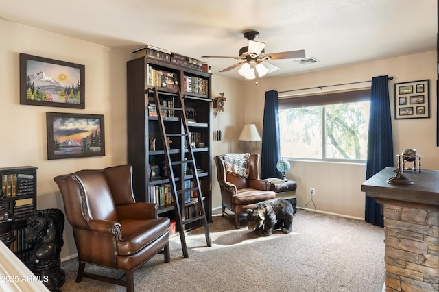 living area featuring ceiling fan and carpet