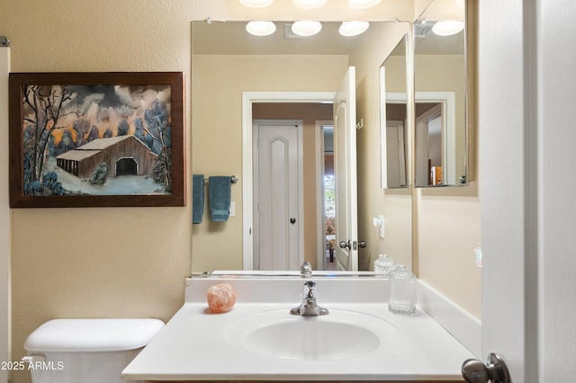 bathroom with toilet and vanity