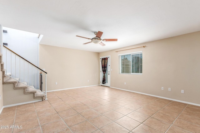 spare room with light tile patterned flooring, ceiling fan, stairway, and baseboards