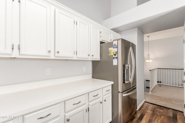 kitchen featuring stainless steel fridge, dark wood finished floors, light countertops, white cabinetry, and pendant lighting