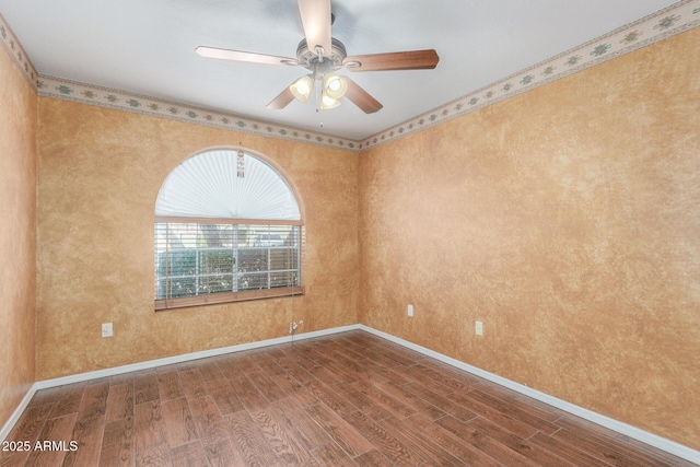 empty room featuring a ceiling fan, baseboards, and wood finished floors