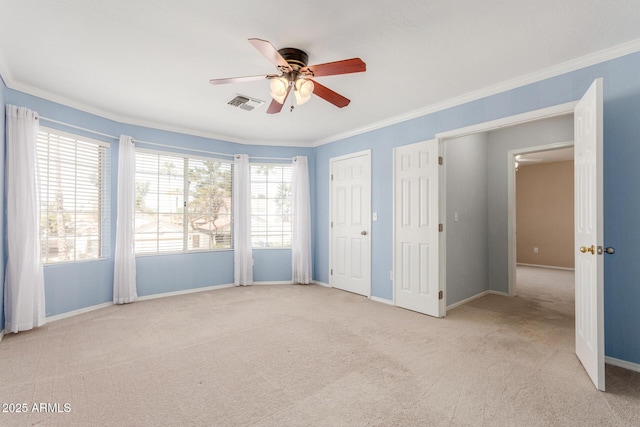 empty room featuring baseboards, visible vents, ceiling fan, crown molding, and carpet floors