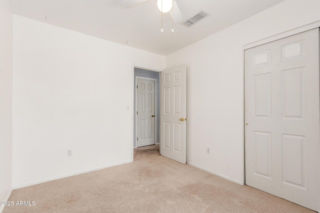 unfurnished bedroom with a ceiling fan, carpet, visible vents, and baseboards