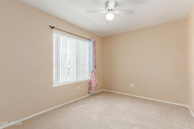 unfurnished room with light colored carpet, ceiling fan, and baseboards