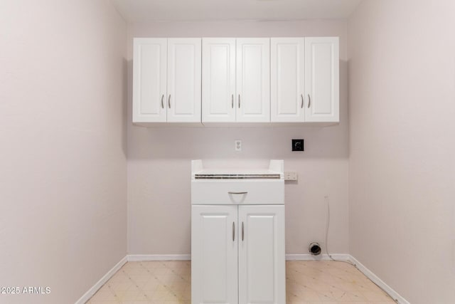 clothes washing area featuring light floors, baseboards, electric dryer hookup, and cabinet space