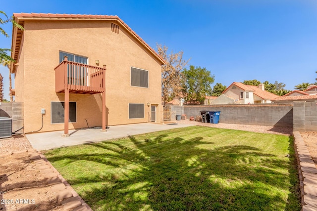 rear view of house featuring a fenced backyard, a lawn, and stucco siding