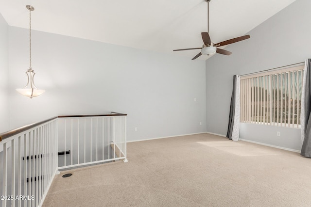 carpeted spare room featuring lofted ceiling and baseboards