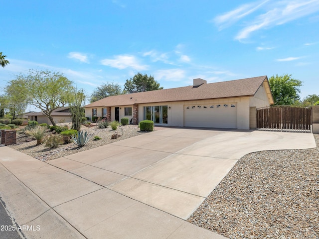 single story home with an attached garage, fence, a gate, and concrete driveway