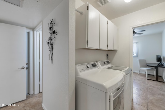 laundry room featuring visible vents, light tile patterned floors, baseboards, cabinet space, and washer and clothes dryer