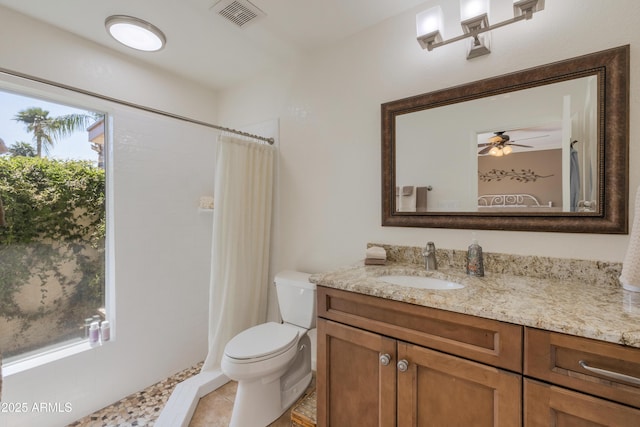 bathroom with a wealth of natural light, vanity, visible vents, and toilet