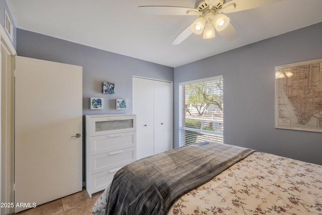 bedroom featuring visible vents, a closet, a ceiling fan, and light tile patterned floors