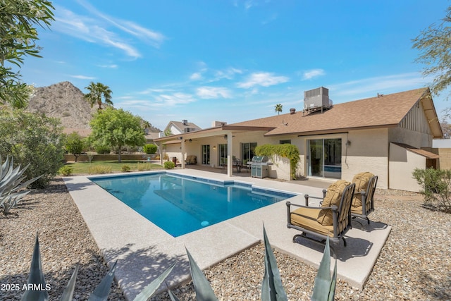 outdoor pool with central AC, a grill, and a patio area