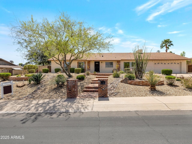 ranch-style home with a garage and stucco siding