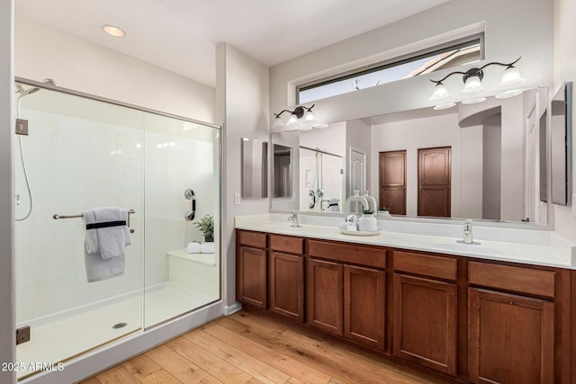 bathroom with vanity, a shower with shower door, and hardwood / wood-style flooring