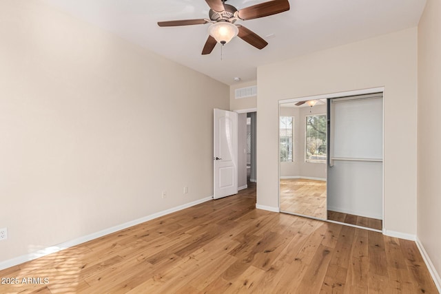 unfurnished bedroom featuring light hardwood / wood-style floors, a closet, and ceiling fan