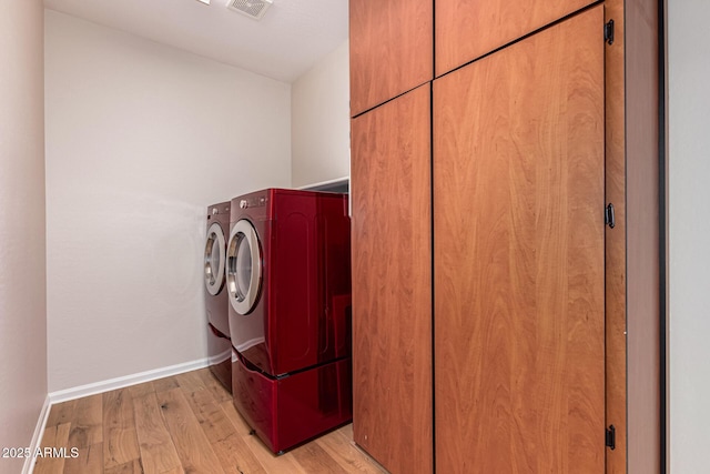 clothes washing area featuring light hardwood / wood-style flooring and washing machine and clothes dryer