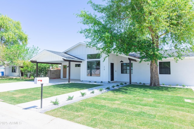 modern farmhouse style home with an attached carport, a front lawn, concrete driveway, and board and batten siding