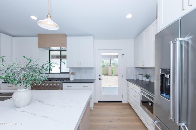 kitchen featuring stainless steel appliances, tasteful backsplash, white cabinets, light wood finished floors, and recessed lighting