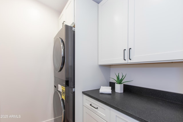 laundry room featuring estacked washer and dryer and cabinet space