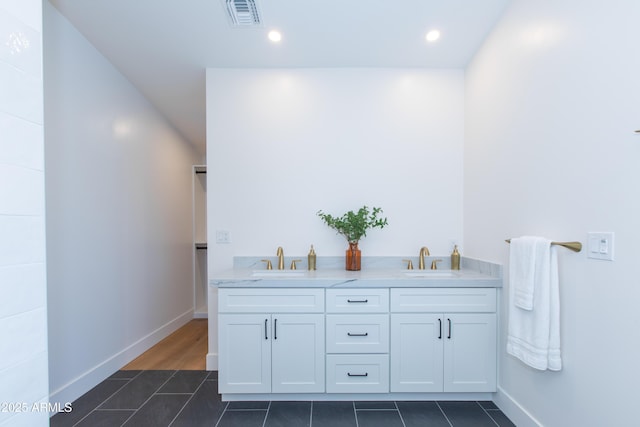 full bath featuring tile patterned floors, baseboards, double vanity, and recessed lighting