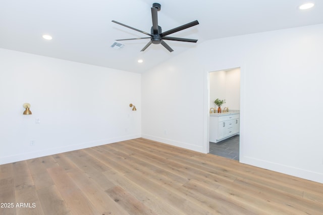 empty room with ceiling fan, vaulted ceiling, recessed lighting, light wood-style floors, and baseboards