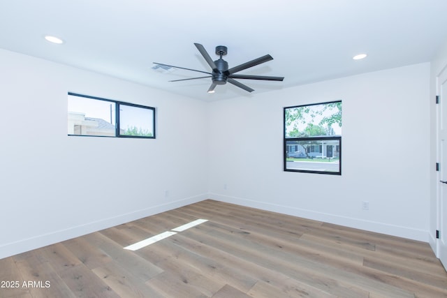 empty room with recessed lighting, a ceiling fan, baseboards, and light wood-type flooring