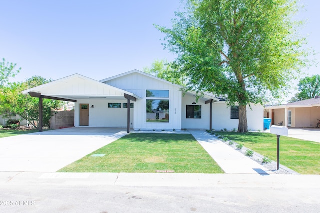 modern farmhouse style home featuring concrete driveway, board and batten siding, and a carport