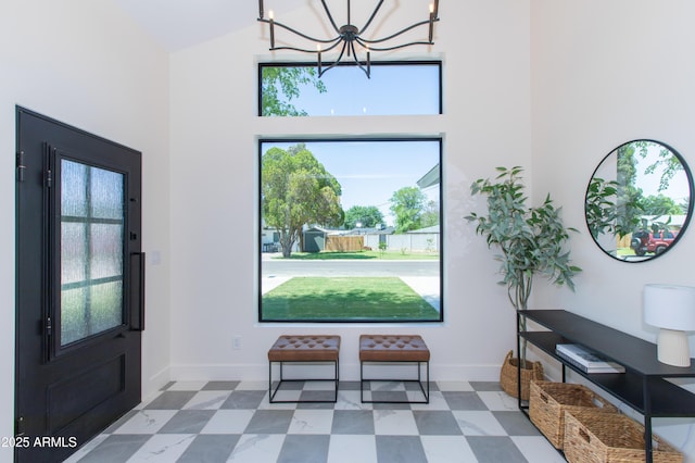 entrance foyer featuring high vaulted ceiling, a chandelier, baseboards, and tile patterned floors