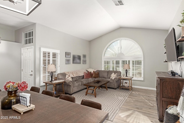 living room with vaulted ceiling and light hardwood / wood-style floors