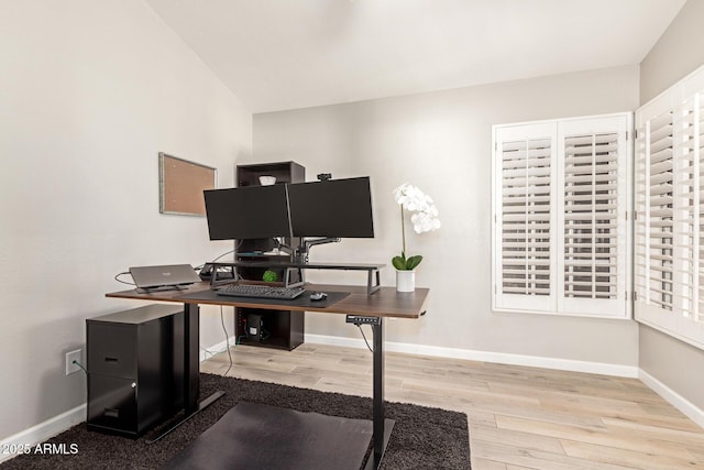 home office with vaulted ceiling and light hardwood / wood-style flooring