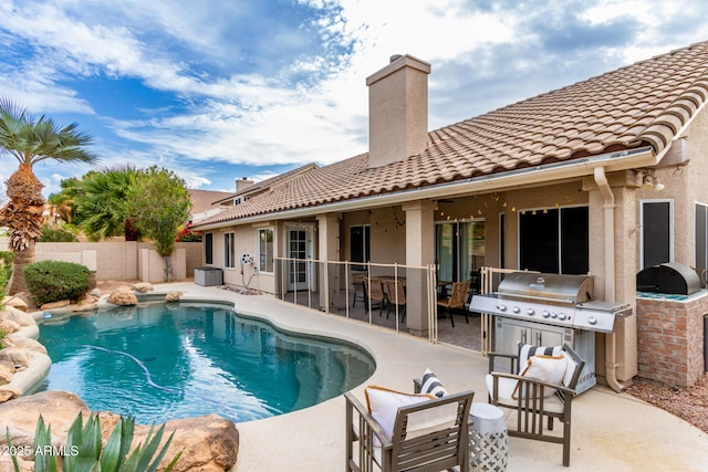 view of swimming pool with grilling area and a patio area