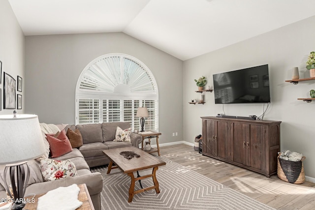 living room featuring vaulted ceiling and light hardwood / wood-style flooring