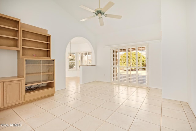 interior space featuring ceiling fan, light tile patterned floors, and high vaulted ceiling