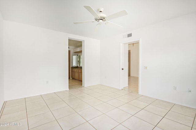 empty room featuring light tile patterned floors and ceiling fan