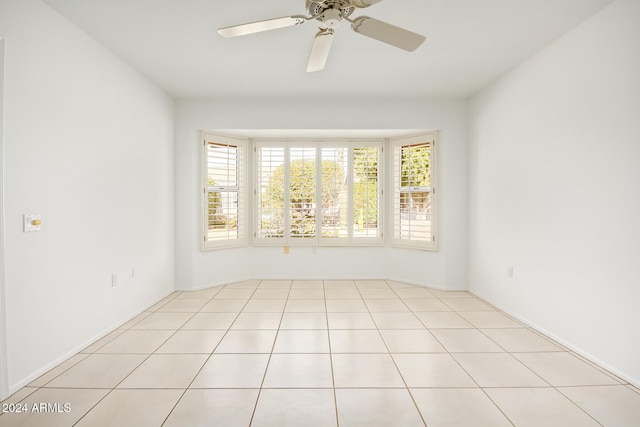 tiled spare room featuring ceiling fan