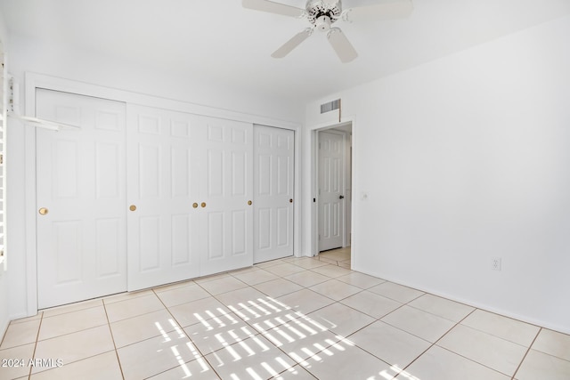 unfurnished bedroom featuring ceiling fan, a closet, and light tile patterned floors