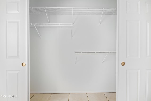 walk in closet with light tile patterned floors