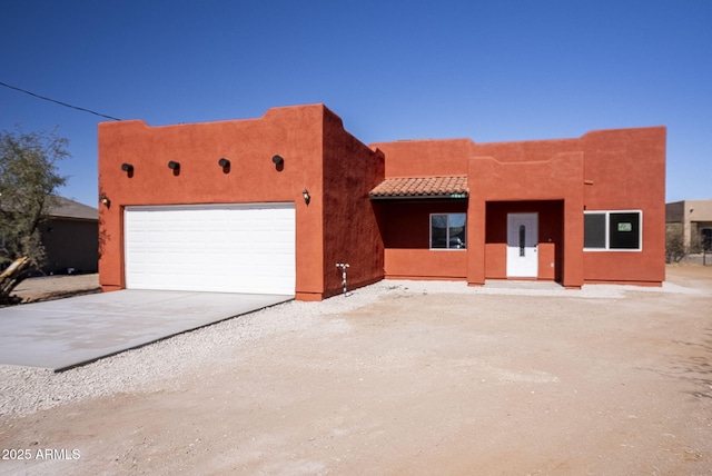 pueblo revival-style home featuring a garage