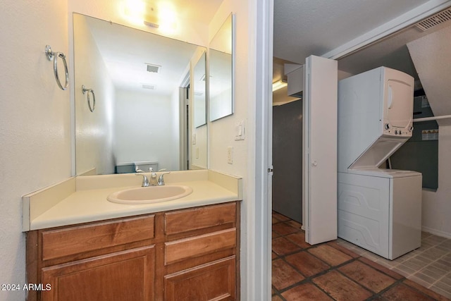 bathroom with stacked washer and clothes dryer and vanity