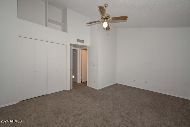 unfurnished bedroom featuring ceiling fan, dark carpet, a closet, and high vaulted ceiling