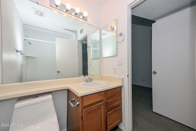 bathroom featuring a shower, vanity, and toilet