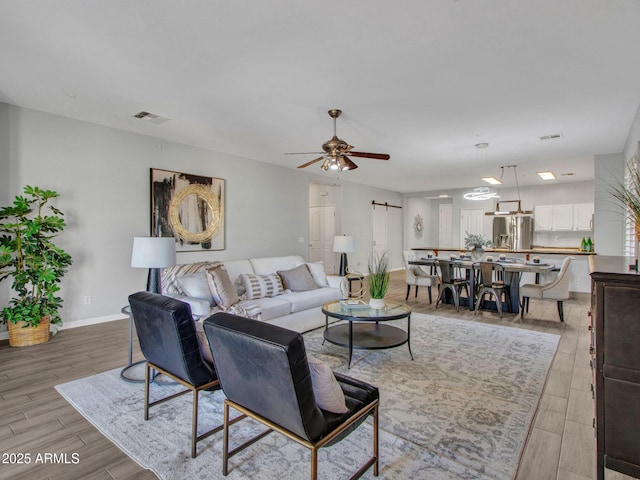 living room featuring ceiling fan and light wood-type flooring