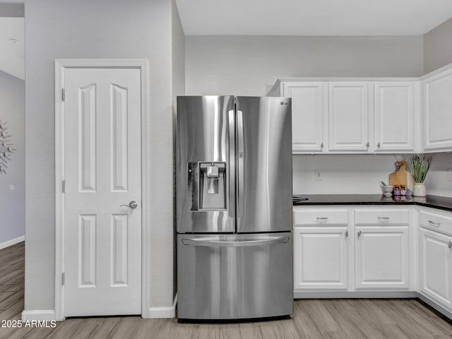 kitchen featuring white cabinetry, stainless steel fridge with ice dispenser, and light hardwood / wood-style flooring