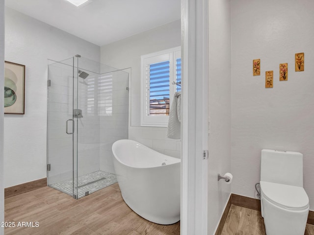 bathroom featuring hardwood / wood-style flooring, shower with separate bathtub, and toilet