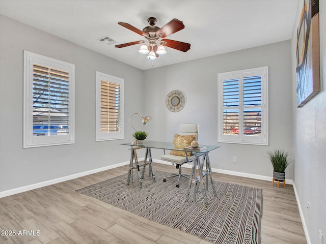 office with ceiling fan and light hardwood / wood-style flooring