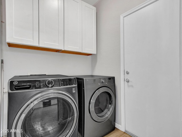 laundry room with cabinets and washer and clothes dryer