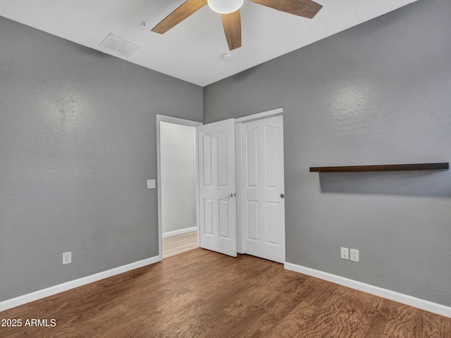 unfurnished bedroom with wood-type flooring, ceiling fan, and a closet