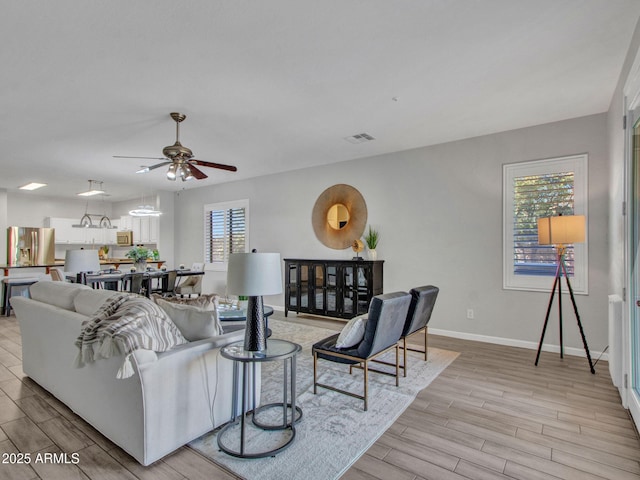 living room with ceiling fan and light hardwood / wood-style floors