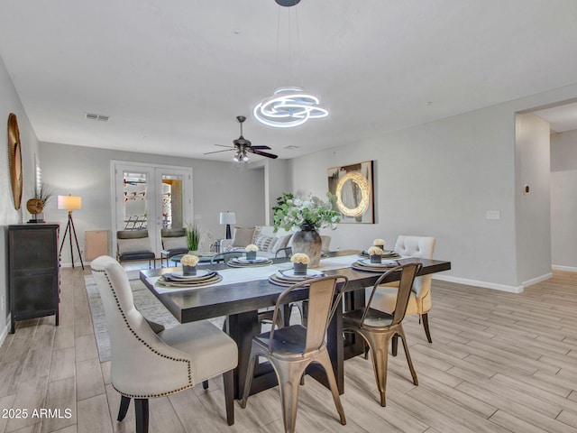 dining space featuring french doors, ceiling fan, and light wood-type flooring